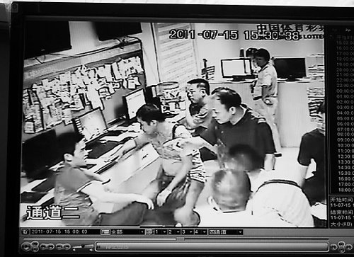 江西貴溪公安局警察在寧波發(fā)帖小伙工作店里溝通時的監(jiān)控錄像截屏。