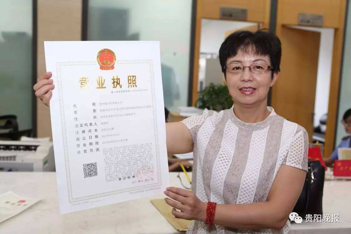 貴州圖片庫(kù)有限公司法定代表人黃曉青從貴州省工商局駐省政務(wù)服務(wù)中心首席代表周立新手中接過(guò)加載統(tǒng)一社會(huì)信用代碼的營(yíng)業(yè)執(zhí)照